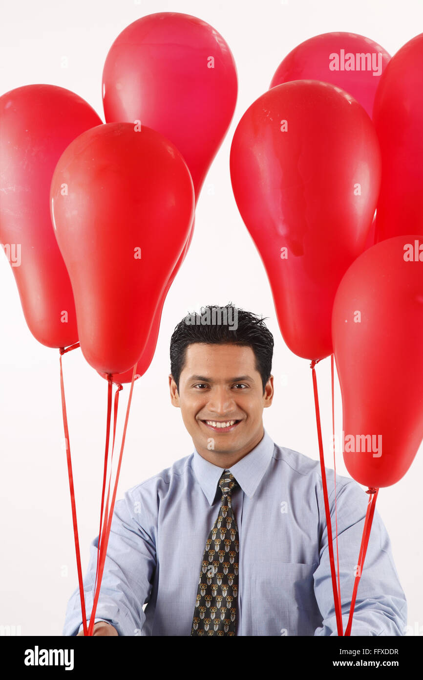 Businessman holding red couleur gaz ballons dans les deux mains MR# 703T Banque D'Images