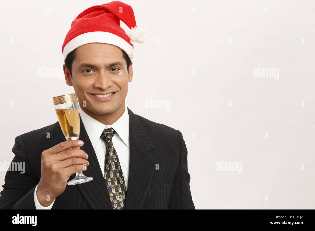 Businessman wearing Santa Clause cap holding wine glass à main droite M.# 703T Banque D'Images