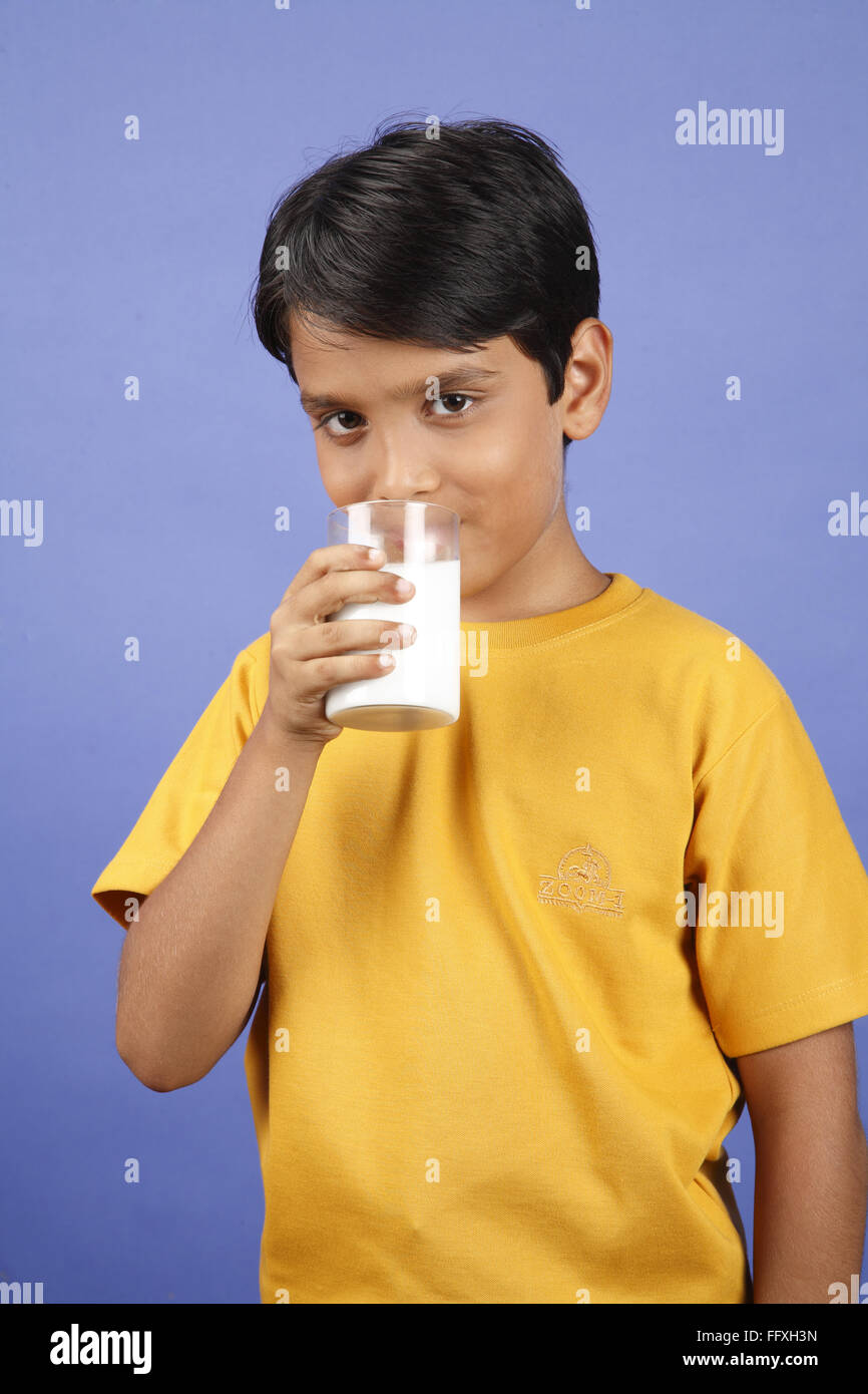 Garçon de dix ans holing verre de lait et boire d'elle MR# 703V Banque D'Images