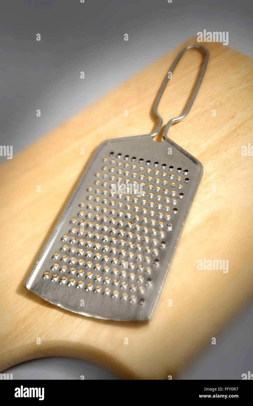 Les choses de cuisine , râpe à fromage sur planche de bois Banque D'Images