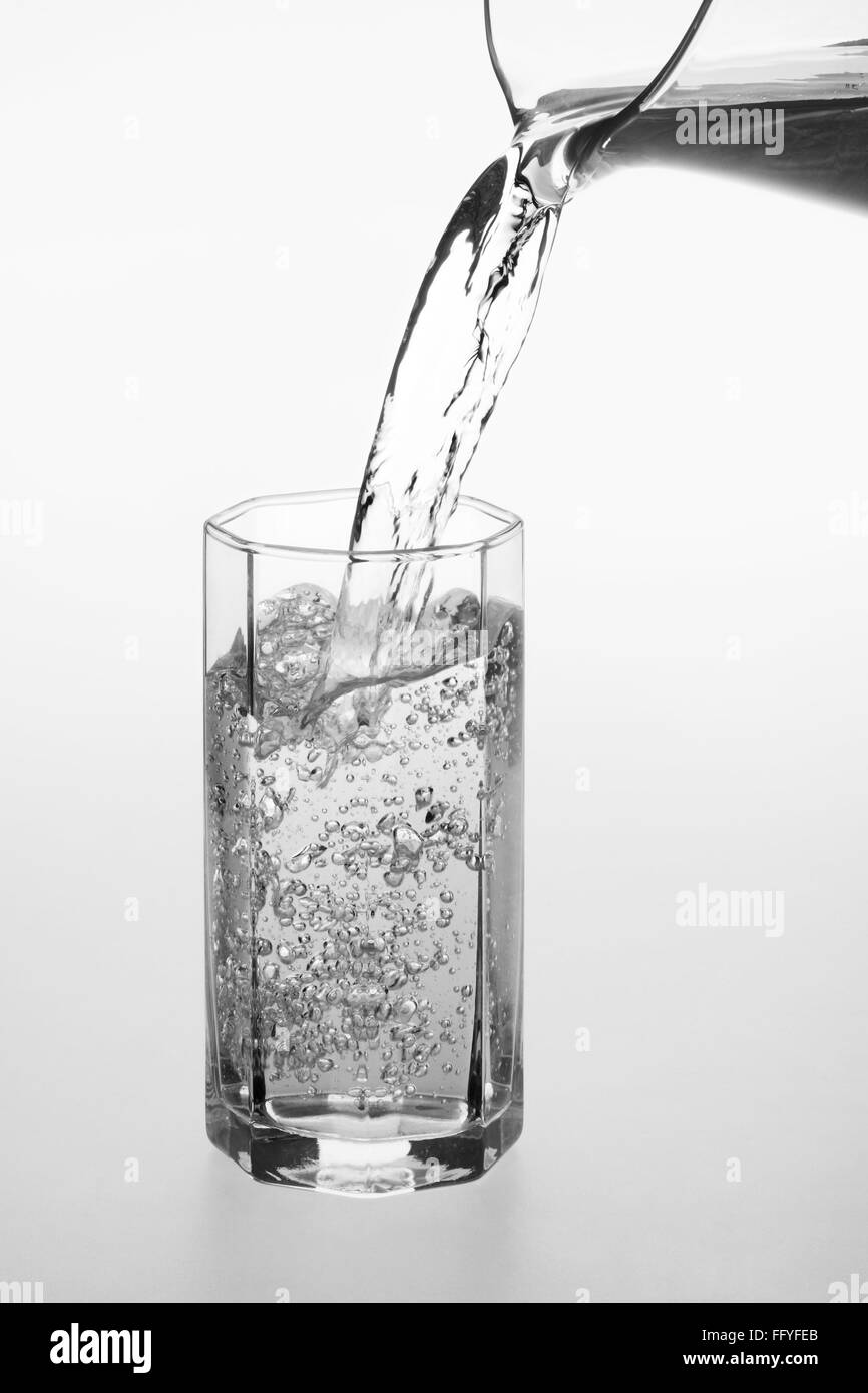 Verser de l'eau dans le verre cristal transparent Banque D'Images