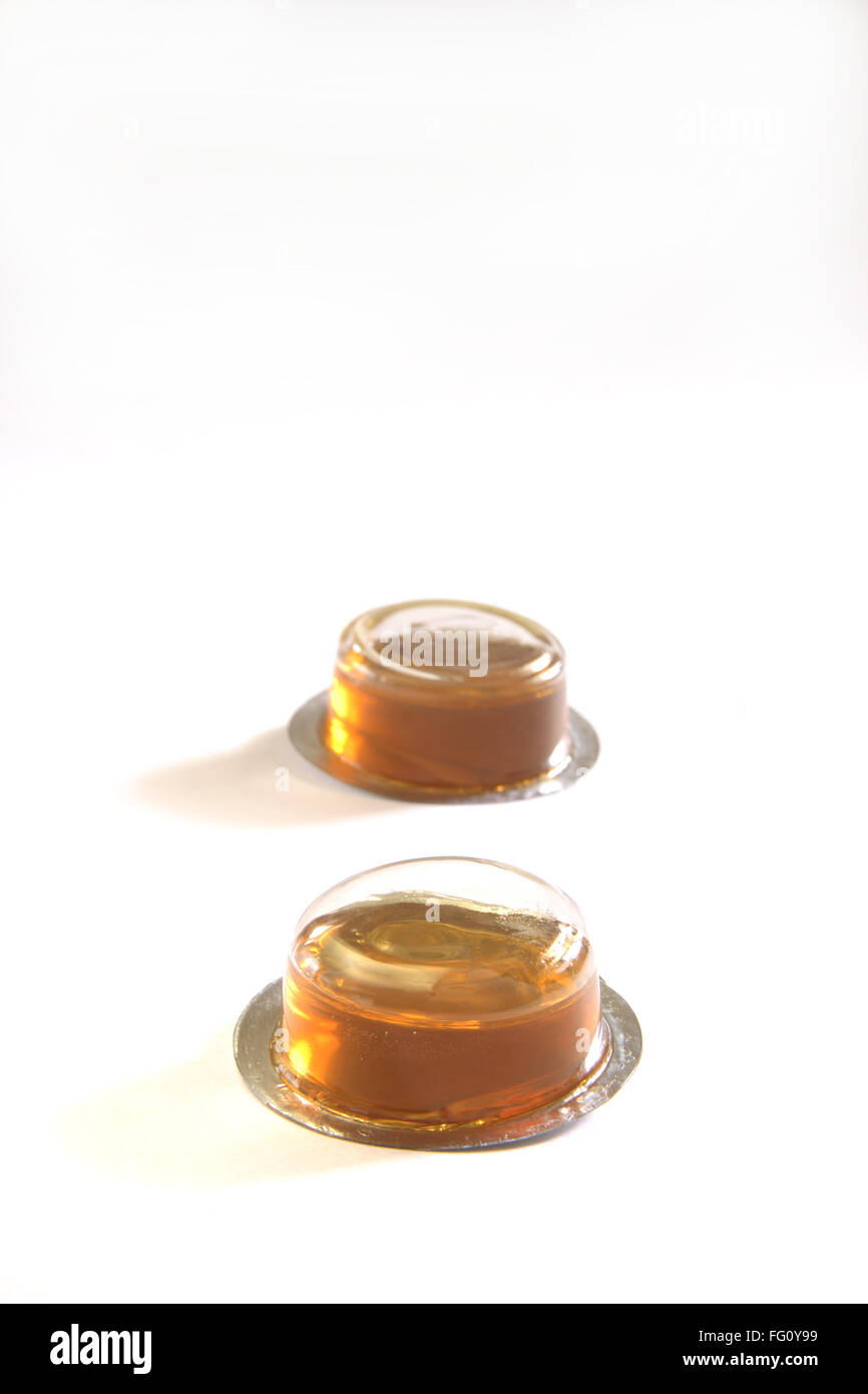 Sticky sweet honey shahad Madhu substance jaunâtre dans des contenants en plastique sur fond blanc Banque D'Images