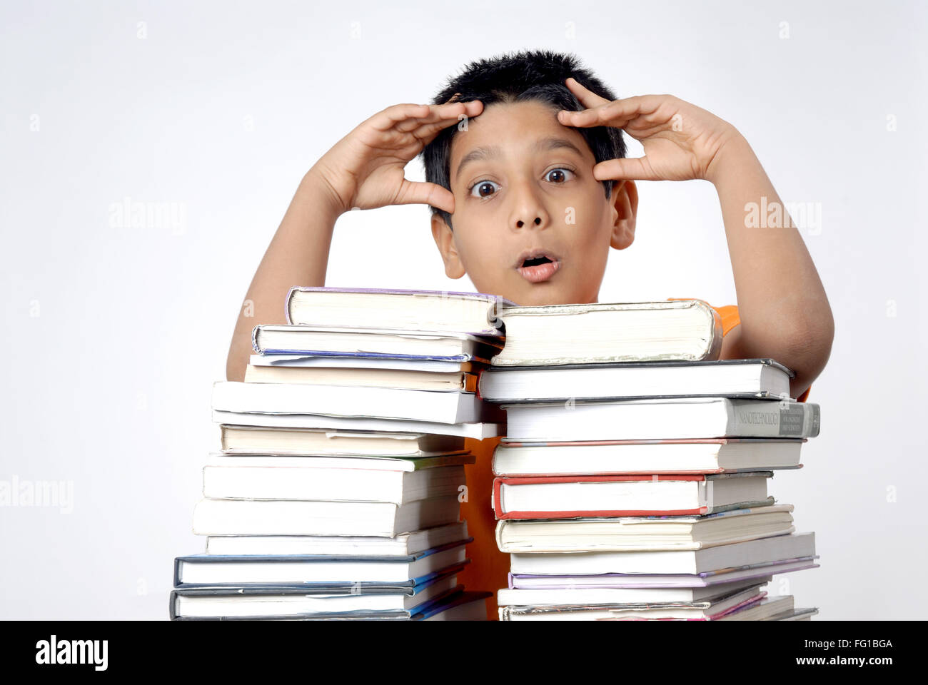 Garçon en tension holding head debout avec pile de livres M.# 152 Banque D'Images