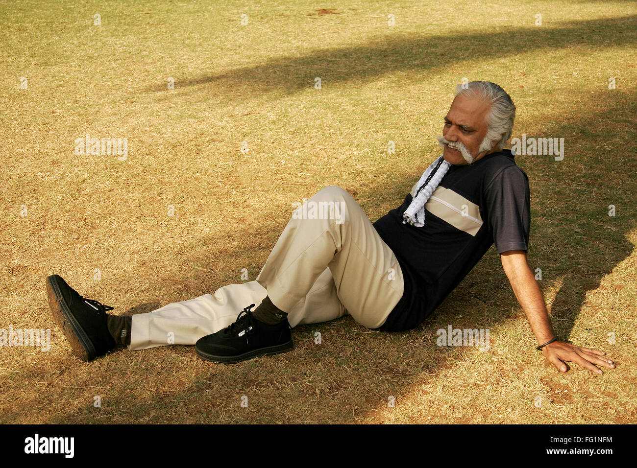 Vieux monsieur avec T-shirt bleu foncé plus de 60 ans et vous reposer à l'ombre dans le parc monsieur# 671 Banque D'Images