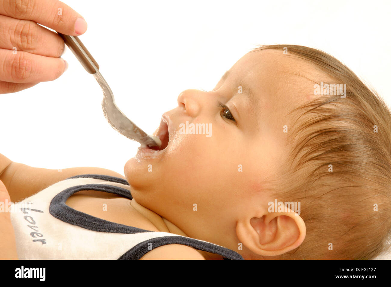 Un an d'alimentation pour bébé garçon couché avec cuillère - M.# 592 Banque D'Images