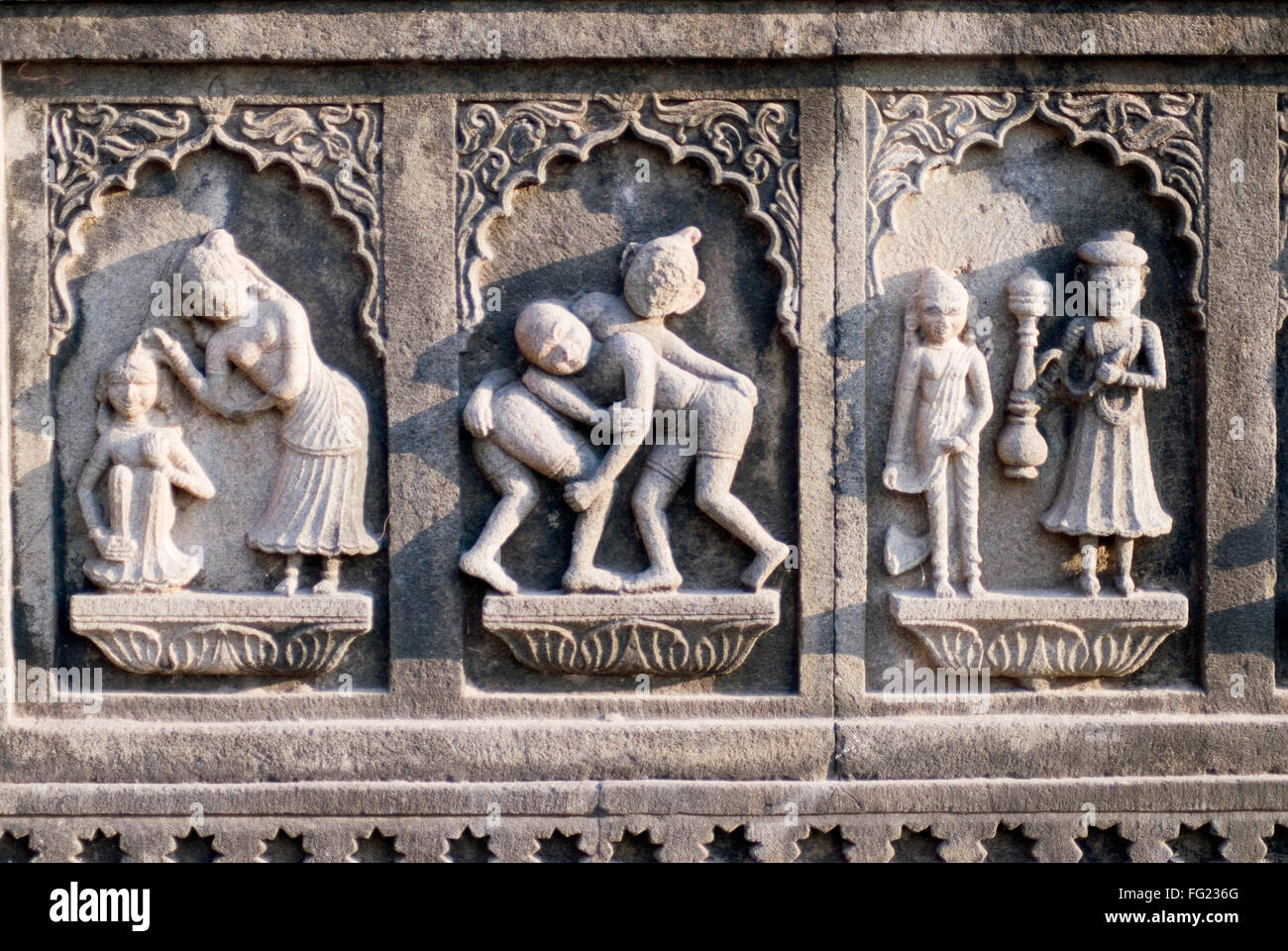 Ou le groupe de secours et lutteur scène de baignade homme femme serviteur mur gravé dans la pierre temple Maheshwar Maheshwar Madhya Pradesh Banque D'Images