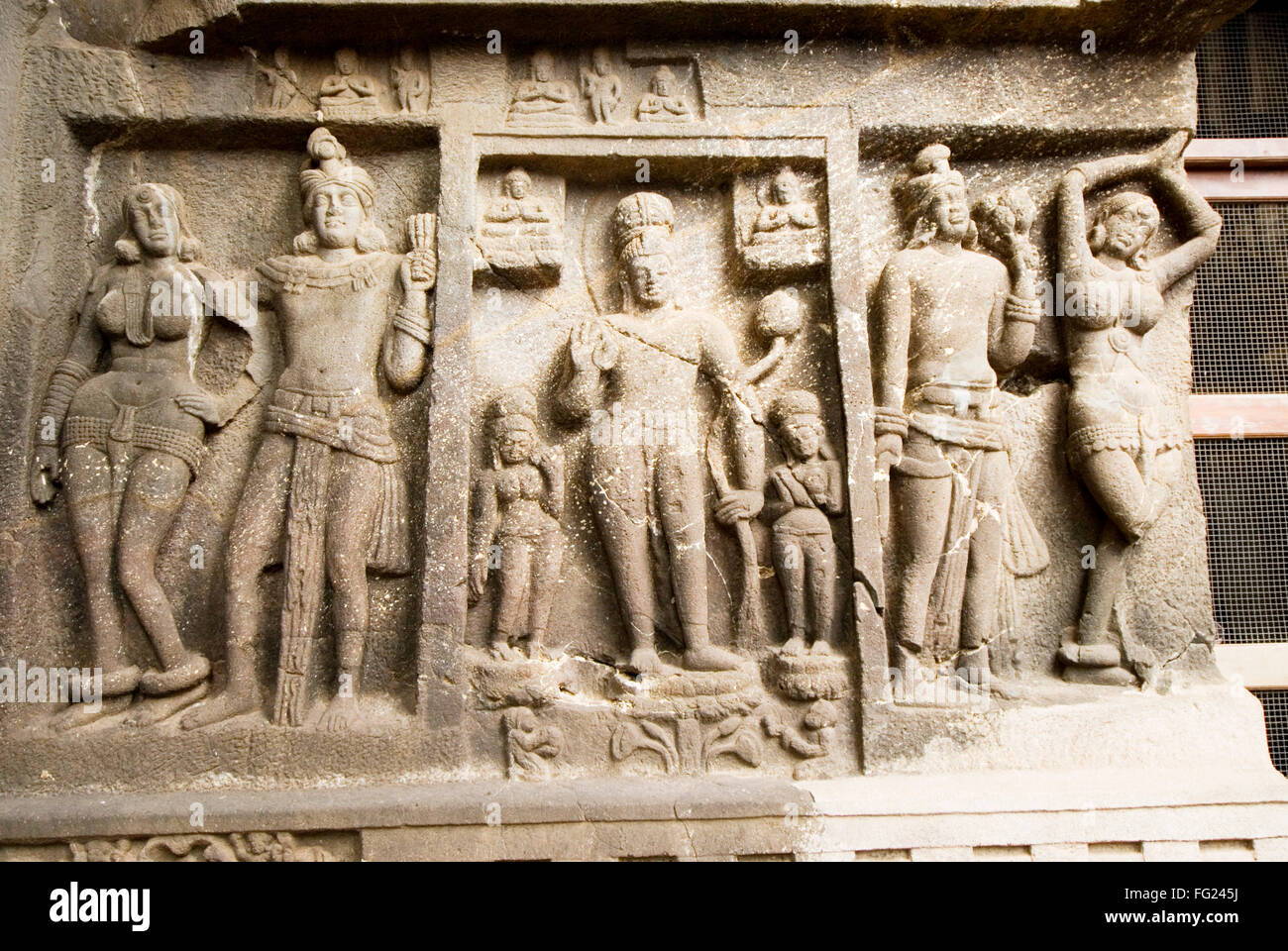 Bouddha au centre et deux couples sculpté dans la pierre sur le mur avant de Karla rock cut cave Chaitya hills Pune Maharashtra Banque D'Images