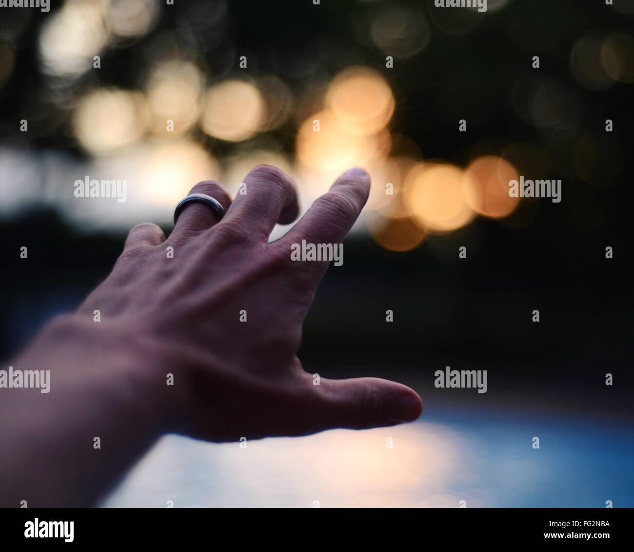 Portrait Of Cropped Hand Pointing at Defocused Lights Banque D'Images