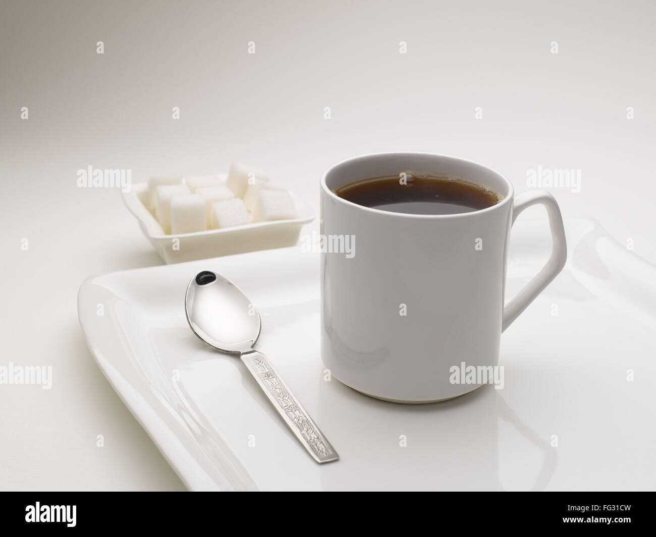 Tasse de thé noir en plat de service avec des morceaux de sucre l'Inde Banque D'Images