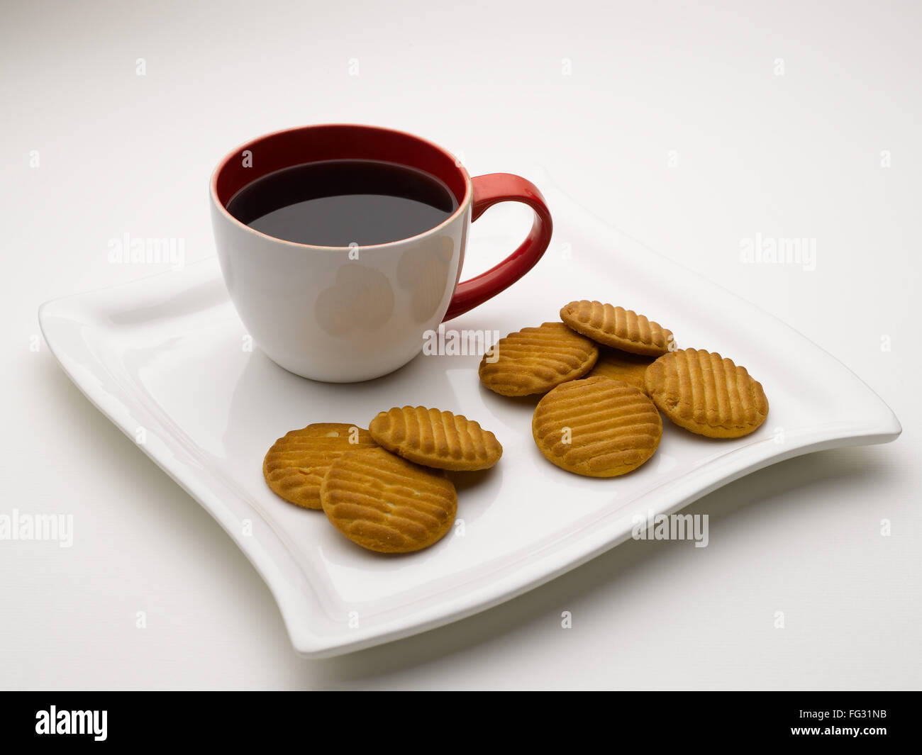 Tasse de thé noir en plat de service avec des biscuits l'Inde Banque D'Images