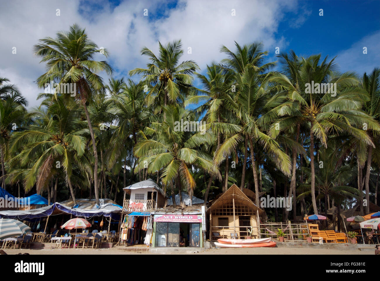 Des cabanes sous les cocotiers et bateaux à plage de Palolem , Goa , Inde Banque D'Images