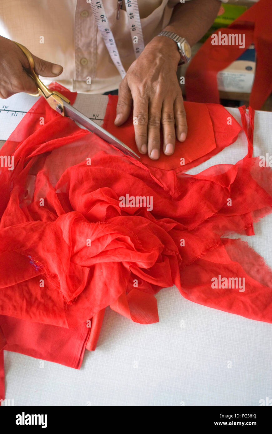 Vieil indien coupe sur mesure tissu rouge avec des ciseaux de fer ; Anjar ; ; ; Inde Gujarat Kutch Banque D'Images