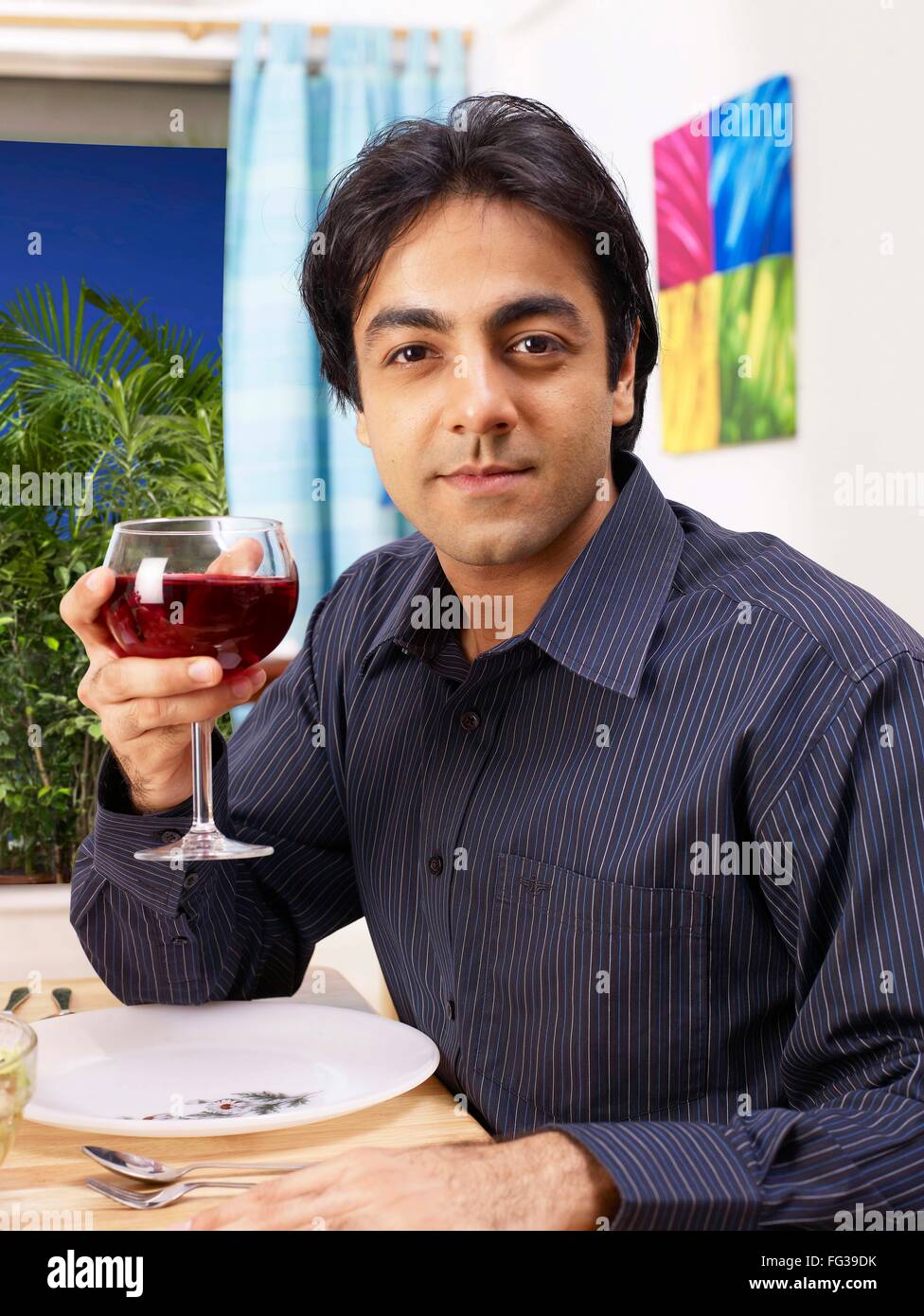 Jeune homme montrant red wine glass MR# 702V Banque D'Images