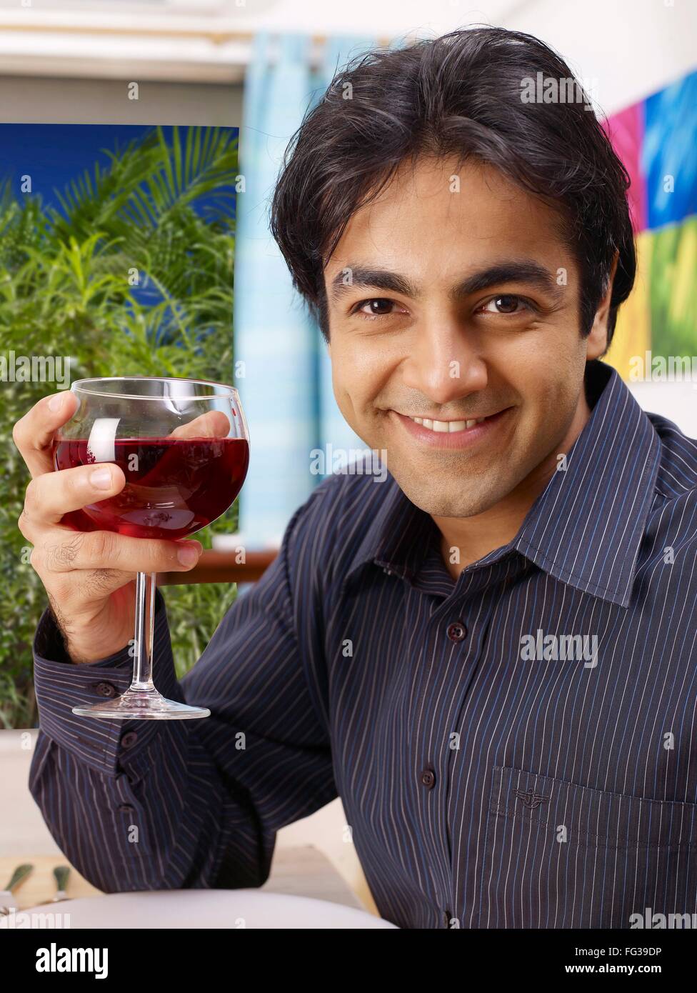Jeune homme montrant red wine glass MR# 702V Banque D'Images
