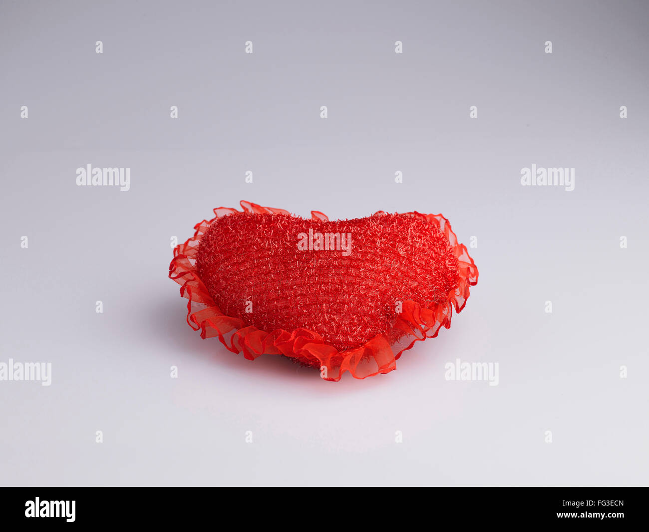 Coussin en forme de coeur de couleur rouge sur fond blanc Banque D'Images