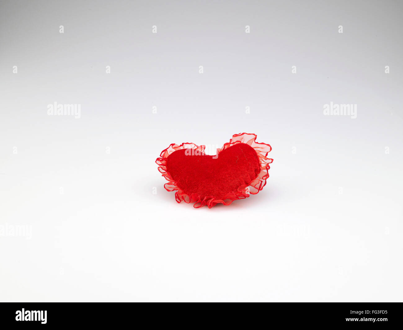 Coussin en forme de coeur de couleur rouge sur fond blanc Banque D'Images