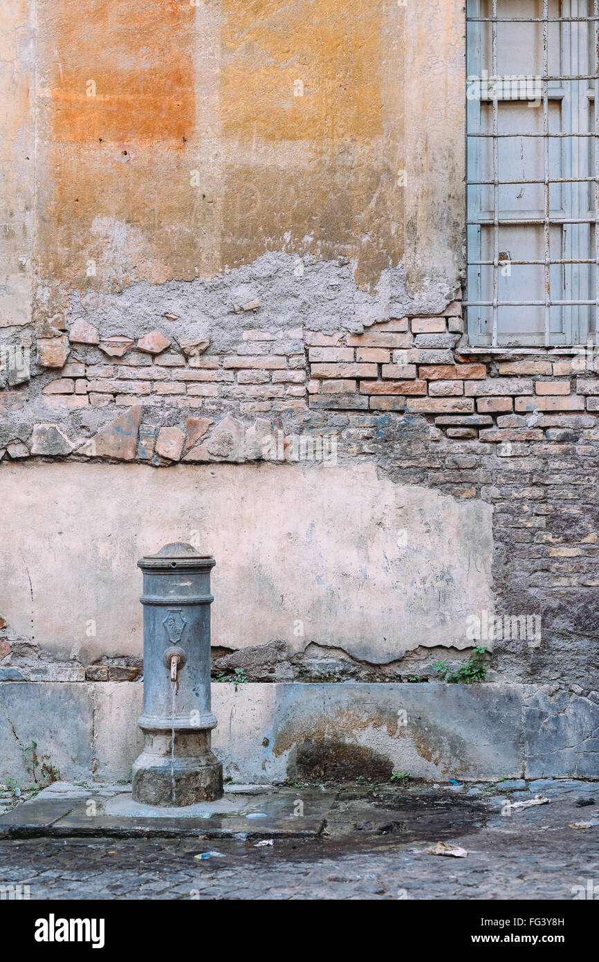 Un 'traditionnels' nasone fontaine à eau dans un coin caché de Rome, Italie Banque D'Images