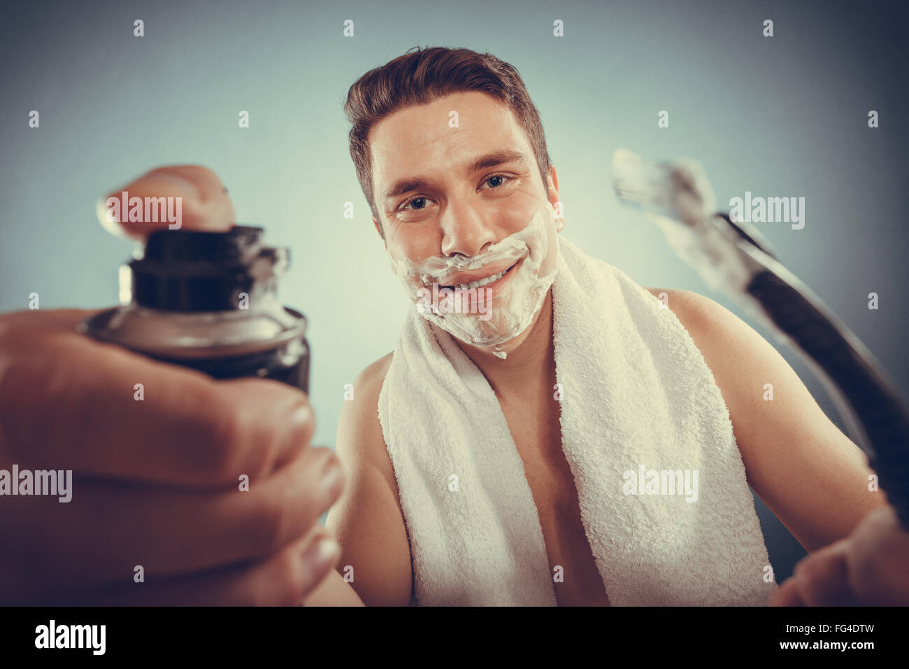 Beau jeune homme barbu avec mousse à raser rasoir et peut préparer pour le rasage. Hygiène et soins de la peau. Filtre Instagram. Banque D'Images