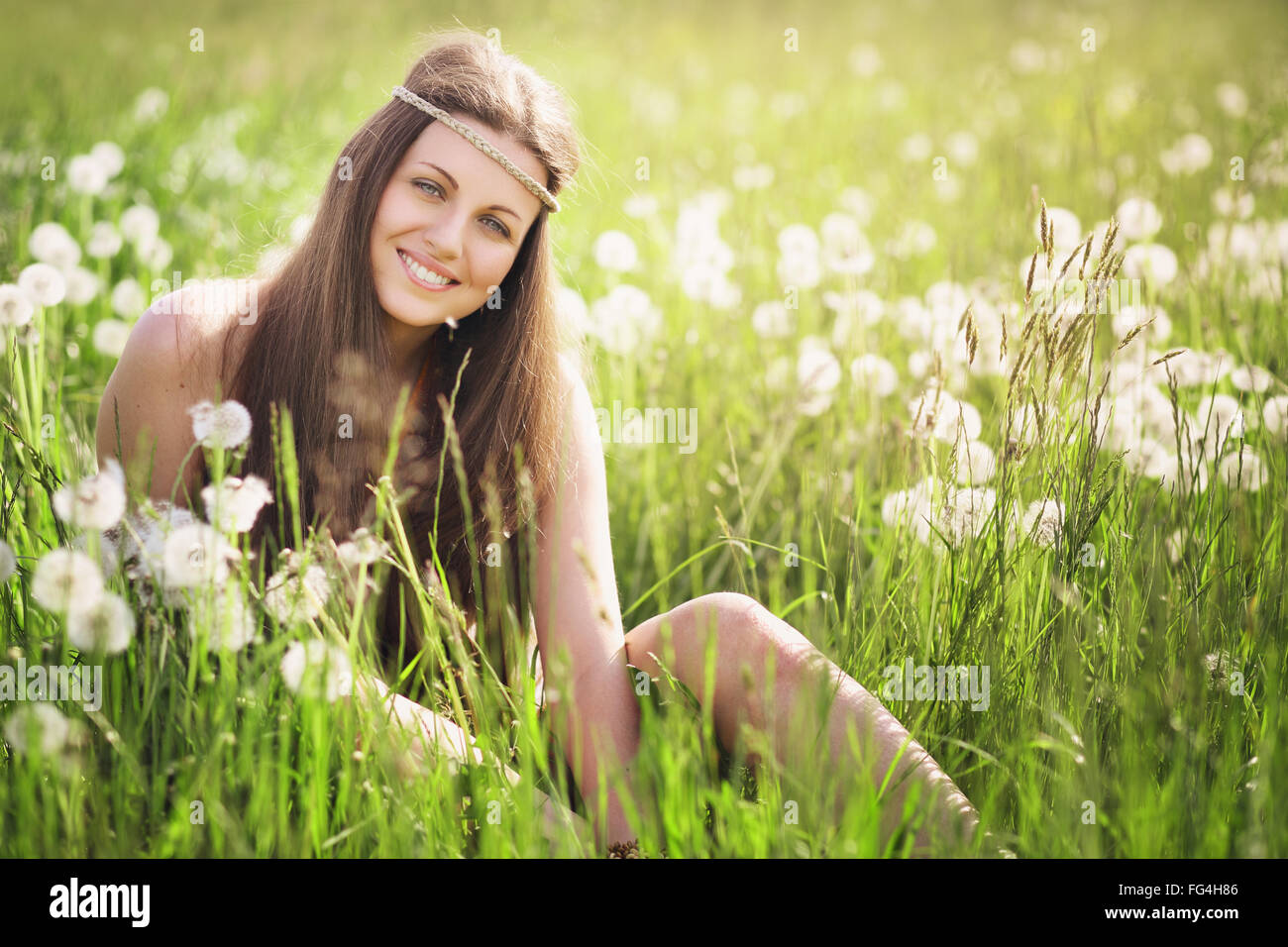 Belle jeune femme souriante dans une prairie fleurie . L'harmonie et la sérénité de la Nature Banque D'Images