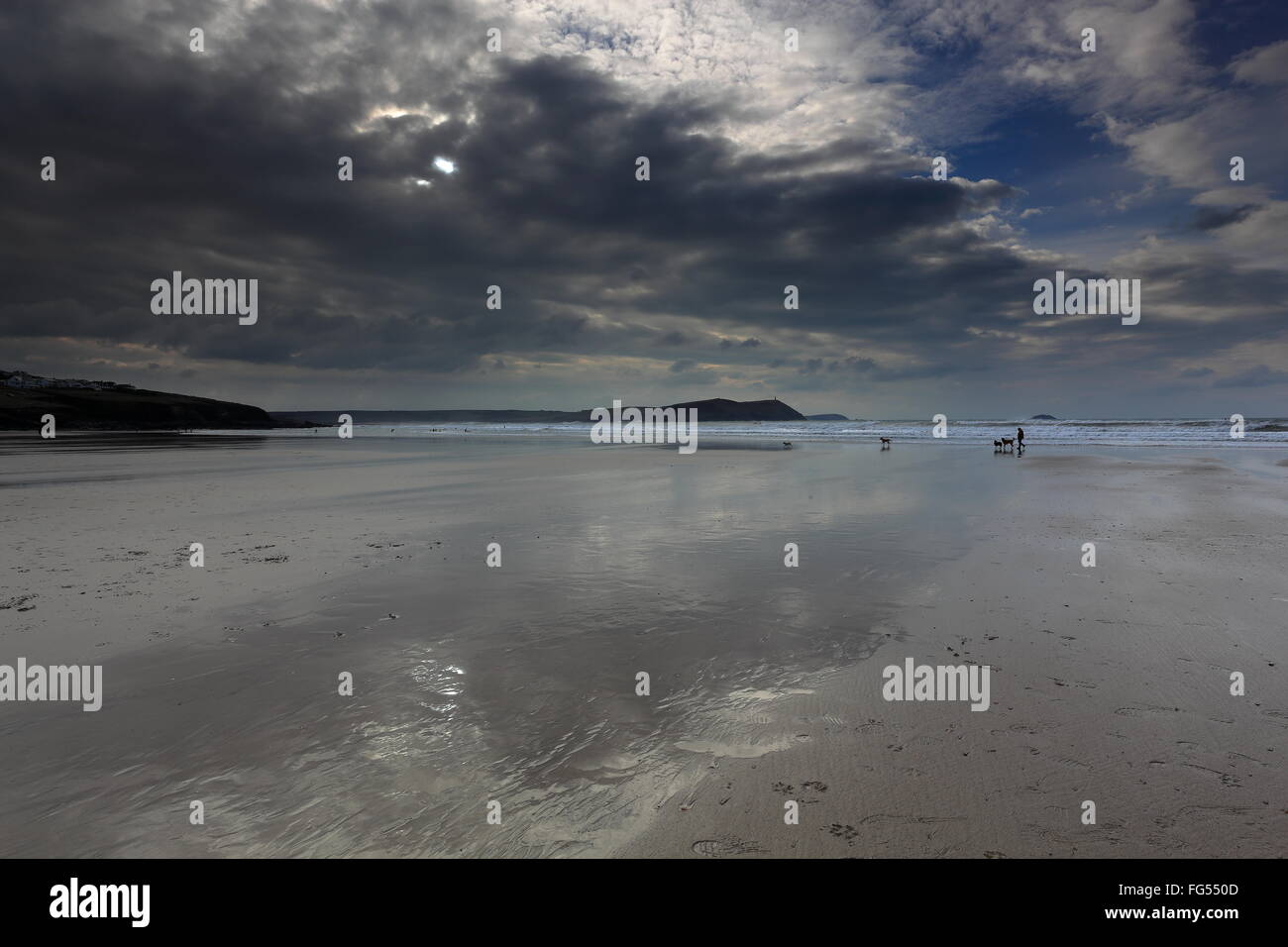 Debout sur la plage de Polzeath, sur la côte nord de la Cornouailles en Angleterre comme un temps orageux front passe au-dessus.. Banque D'Images