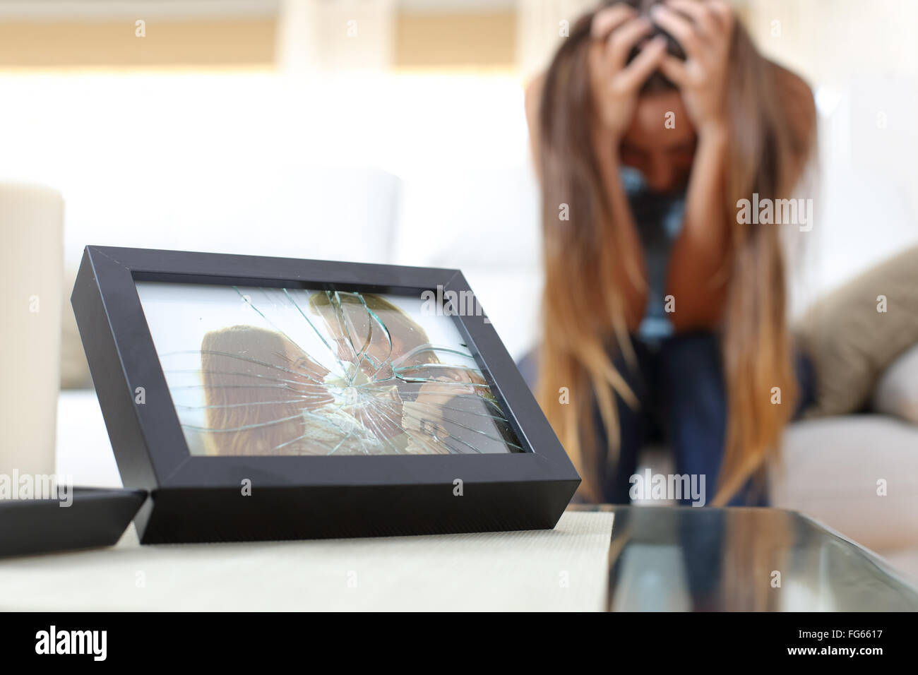 Triste femme désespérée ou petite amie après une liquidation assis dans un canapé à la maison Banque D'Images