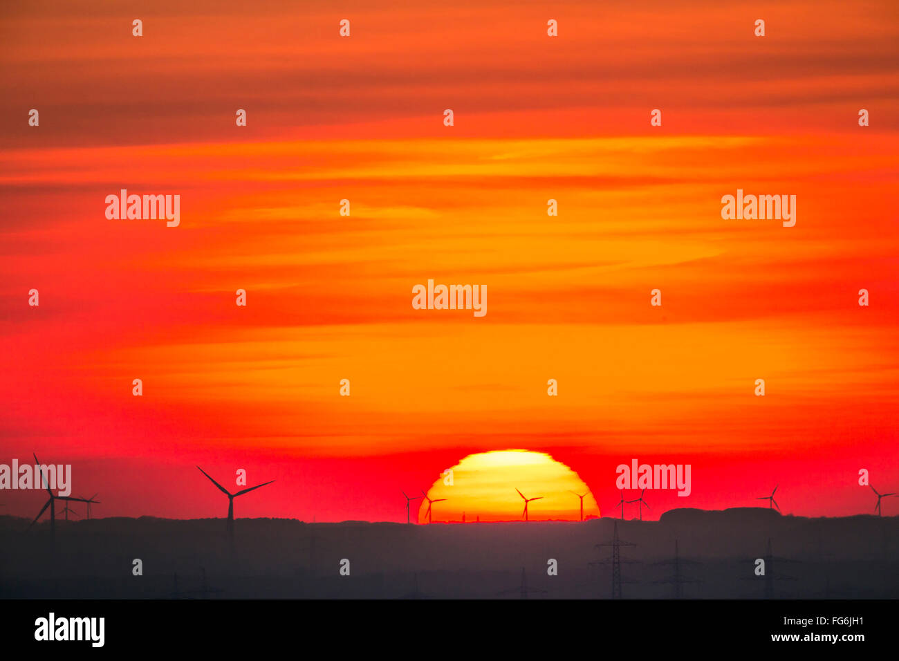 Coucher du soleil dans la région de la Ruhr et la région du Bas Rhin, l'Allemagne, de parcs éoliens, l'énergie éolienne, les éoliennes, les lignes électriques, les poteaux d'électricité Banque D'Images