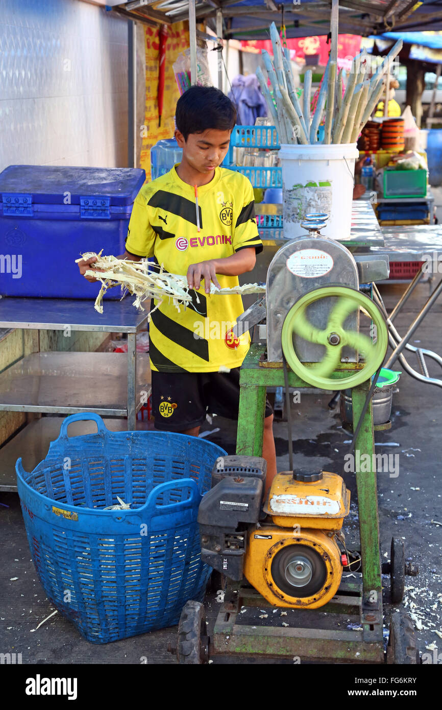 Boy making Durian jus dans la rue en appuyant sur les fruits, Yangon, Myanmar Banque D'Images