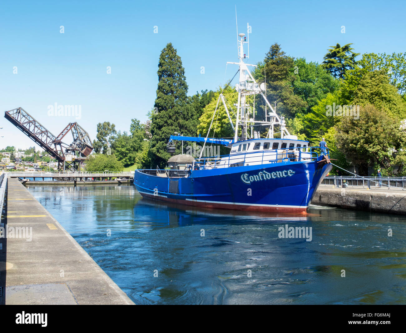 Un bateau de pêche flotte dans une écluse avec un pont en arrière-plan, Ballard Locks, Seattle, Washington, USA, l'été Banque D'Images