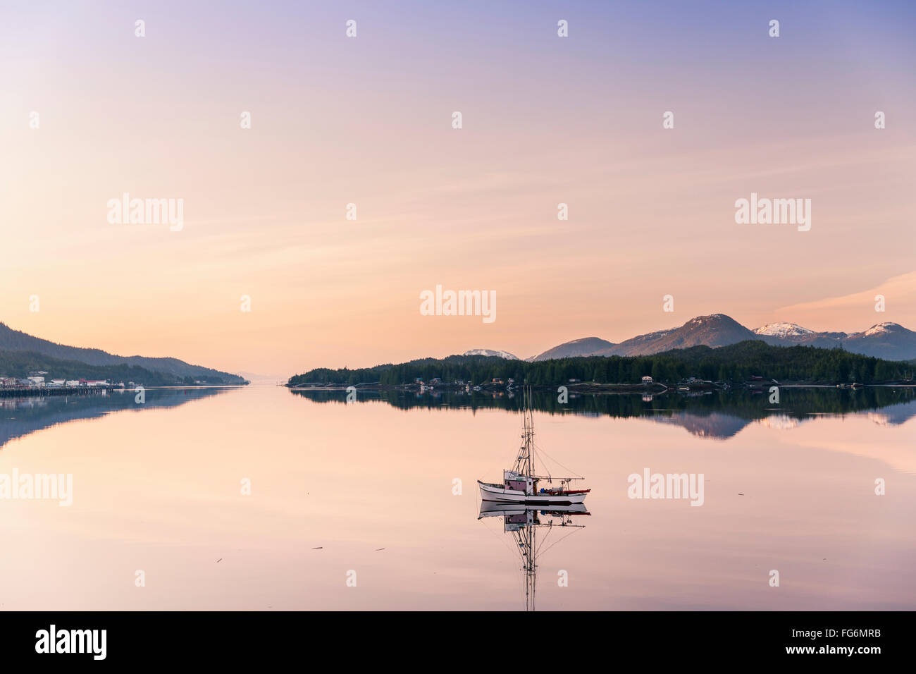 Scenic lever du soleil sur un petit bateau de pêche se reflétant dans le port de Ketchikan, Alaska du Sud-Est, le ressort Banque D'Images