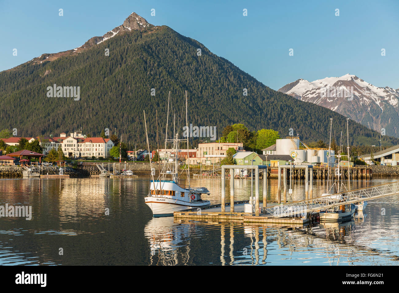 Bateau de pêche amarré le long de la jetée dans le port de Sitka et les montagnes en arrière-plan, le sud-est de l'Alaska, USA, l'été Banque D'Images