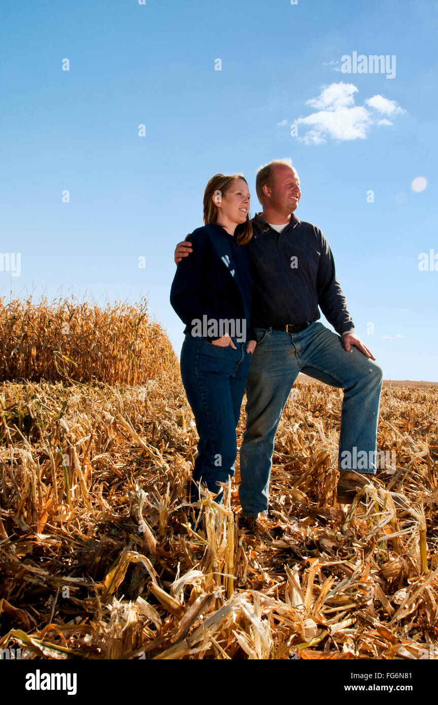 Agriculture - mari et femme posent ensemble dans un champ de maïs-grain récolté en partie à l'automne / près de Sioux City, Iowa, États-Unis. Banque D'Images