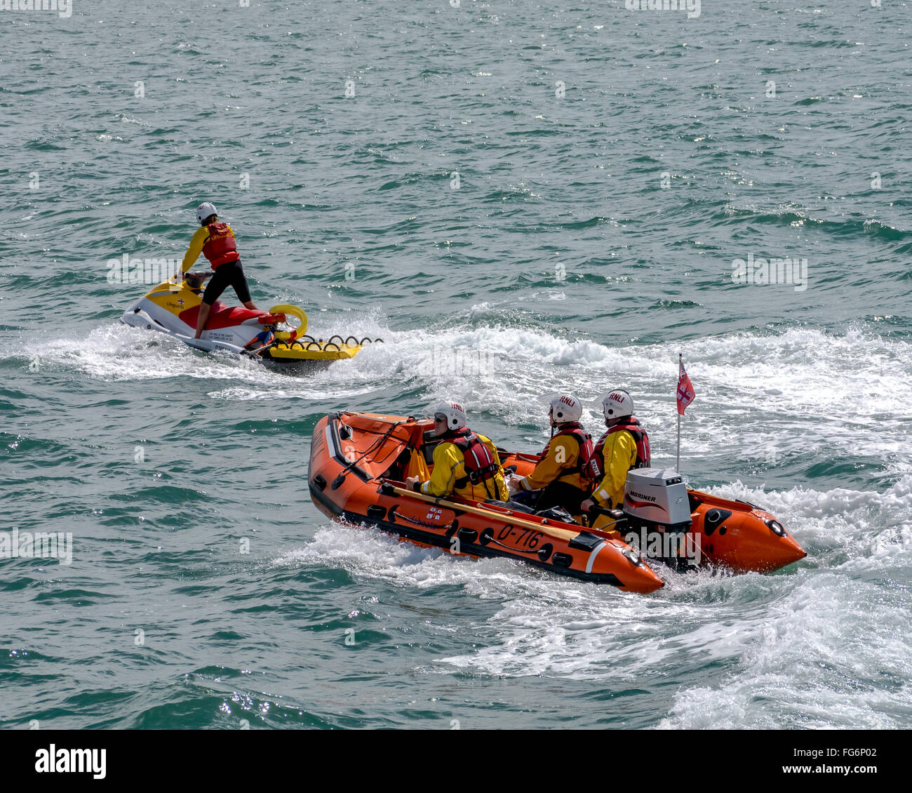 Un bateau gonflable rigide et d'un scooter de la RNLI patroling la côte en mer Banque D'Images