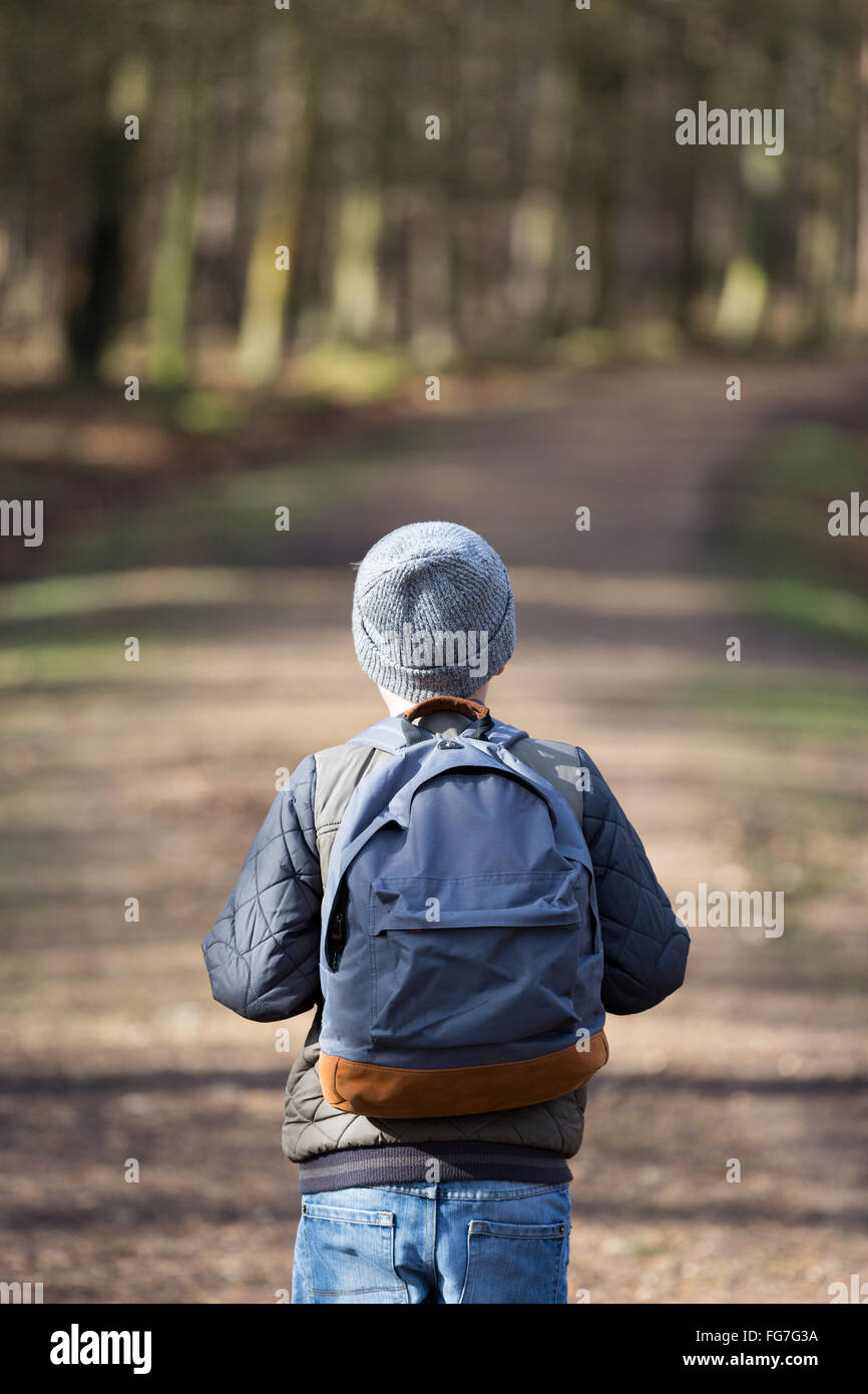 Un garçon avec un sac à dos randonnée dans les bois Banque D'Images