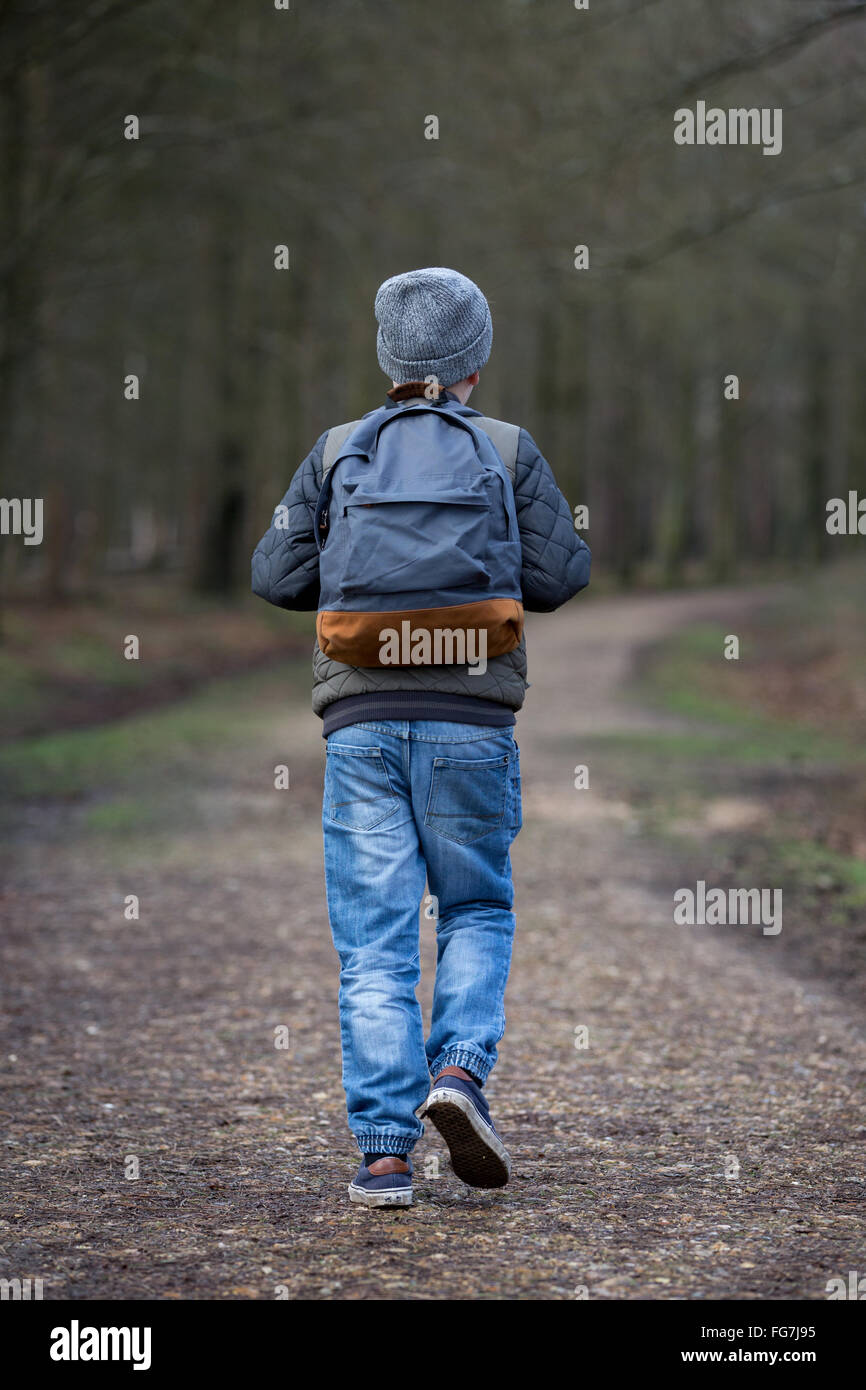 Un garçon avec un sac à dos randonnée dans les bois Banque D'Images