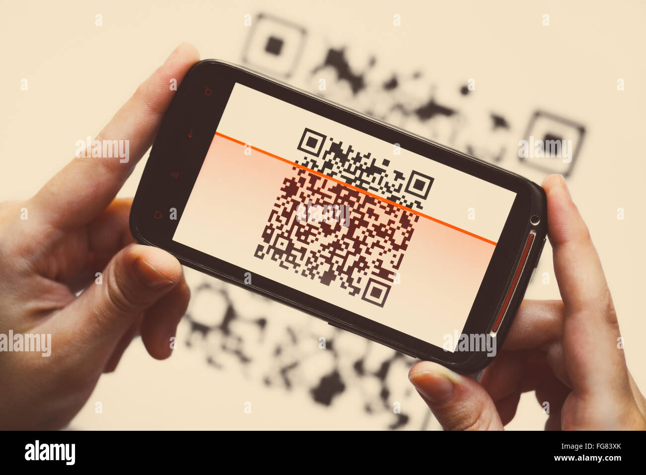 Deux mains tenant un téléphone portable scanner un QR code Banque D'Images