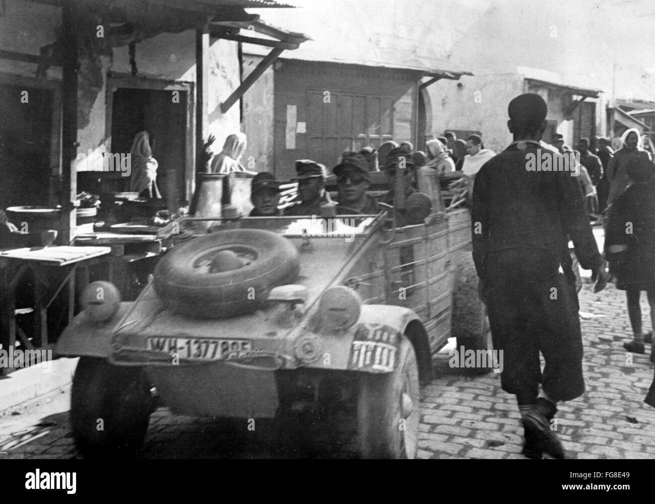 Le tableau de la propagande nazie montre des soldats de la Wehrmacht allemande dans une Volkswagen Type 83 (Kuebelwagen) dans la ville occupée Tunis, Tunisie. La photo a été publiée en février 1943. Fotoarchiv für Zeitgeschichtee - PAS DE SERVICE DE VIREMENT - Banque D'Images