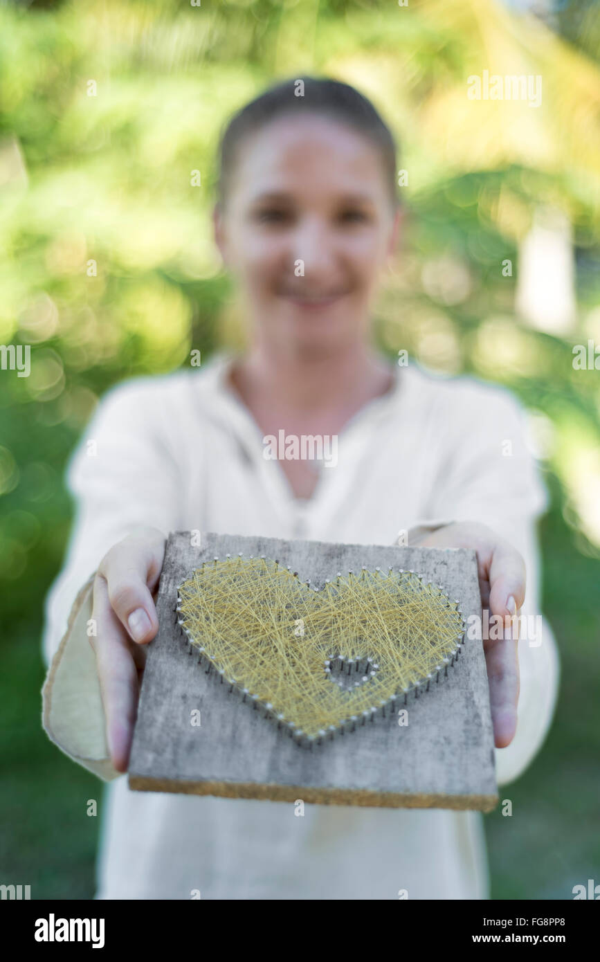 Young caucasian woman showes cœur symbolique Banque D'Images