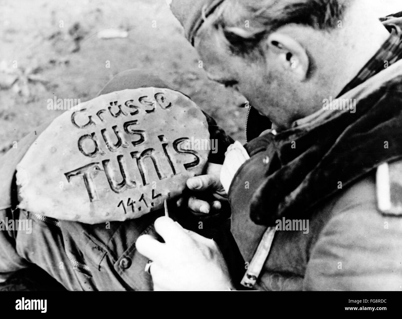 Le tableau de la propagande nazie montre un soldat de la Wehrmacht allemande qui a réalisé un tableau d'accueil avec les mots 'Gruesse aus Tunis' (salutation éclairée de Tunis) dans la ville occupée de Tunis en Tunisie. La photo a été publiée en février 1943. Fotoarchiv für Zeitgeschichte - PAS DE SERVICE DE VIREMENT - Banque D'Images