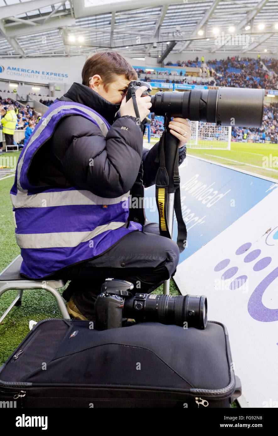 Sports Football Féminin photographe au travail avec téléobjectif long pitchside prendre des photos Banque D'Images