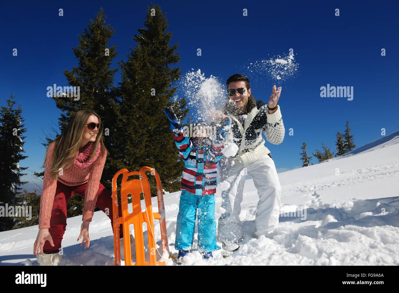 Family having fun sur la neige fraîche au winter Banque D'Images