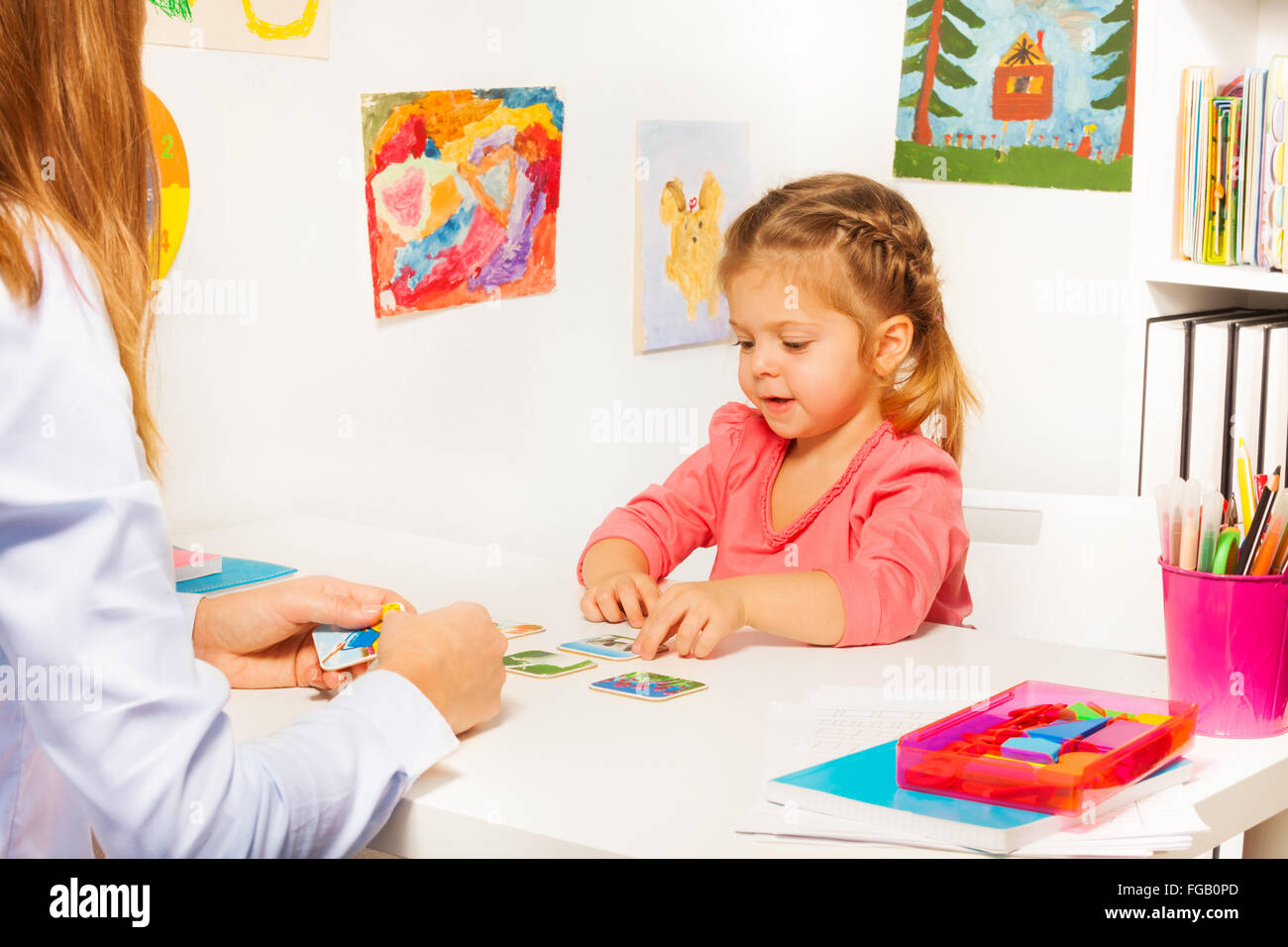 Petite fille de prendre des cartes de table dans la classe Banque D'Images