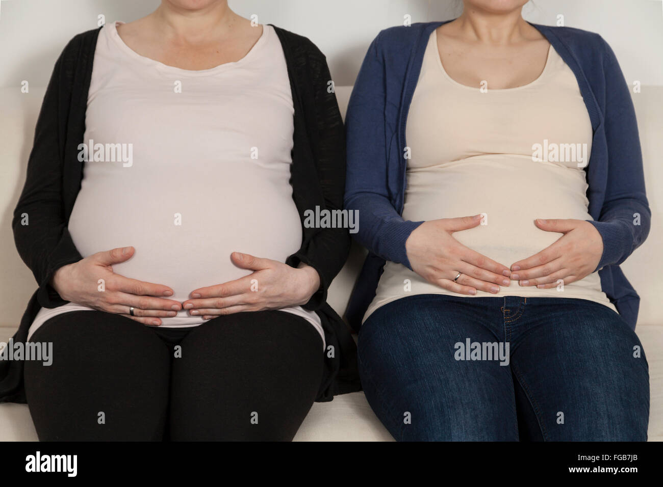 Deux femmes enceintes sitting on sofa Banque D'Images