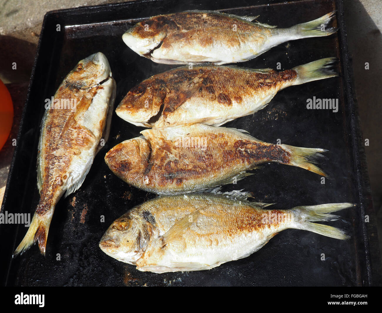 De poisson entier grillé sur un barbecue en cours Banque D'Images