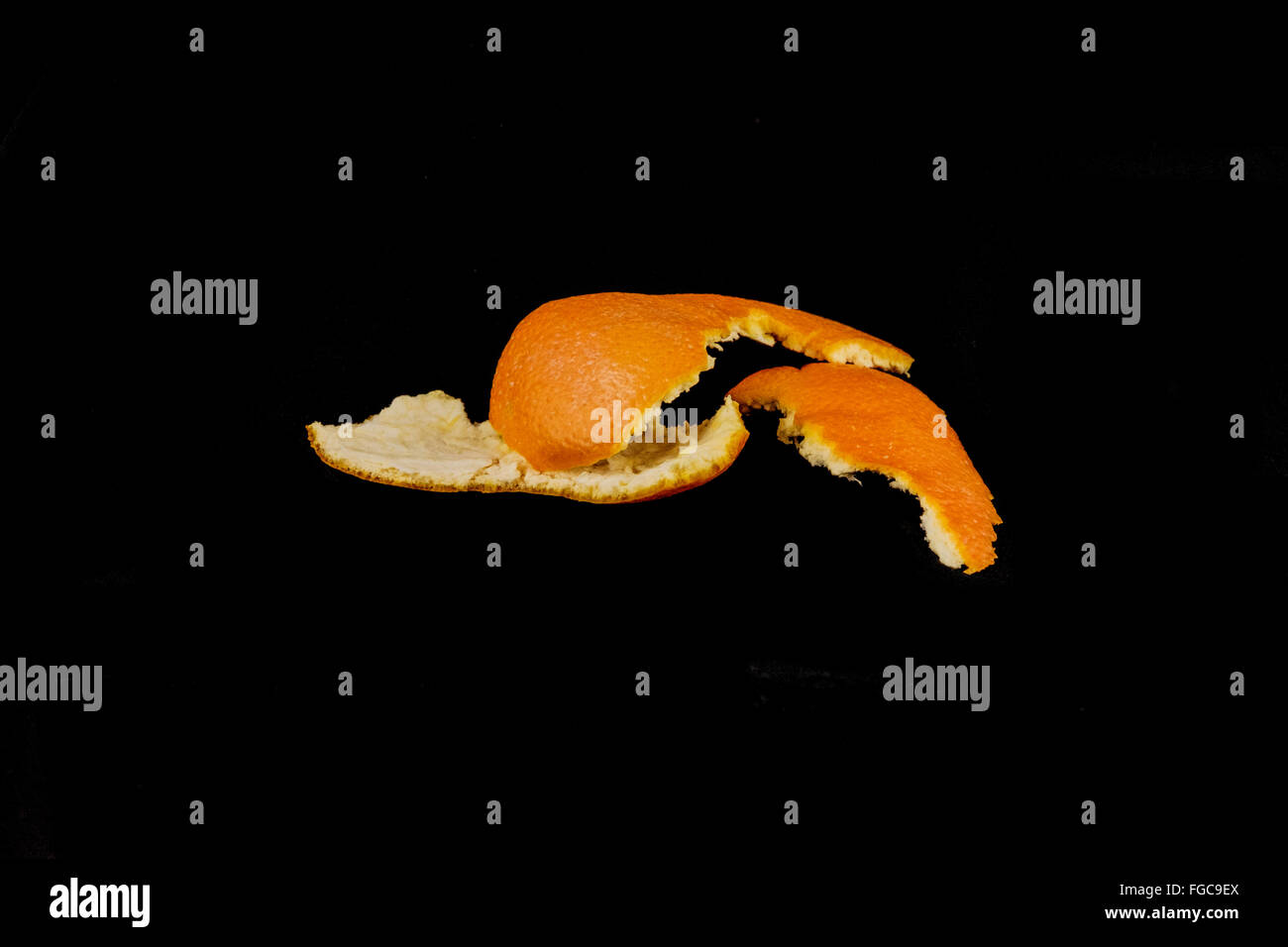 Le peeling de la marine une orange, Citrus sinensis x, sur un fond noir. Banque D'Images