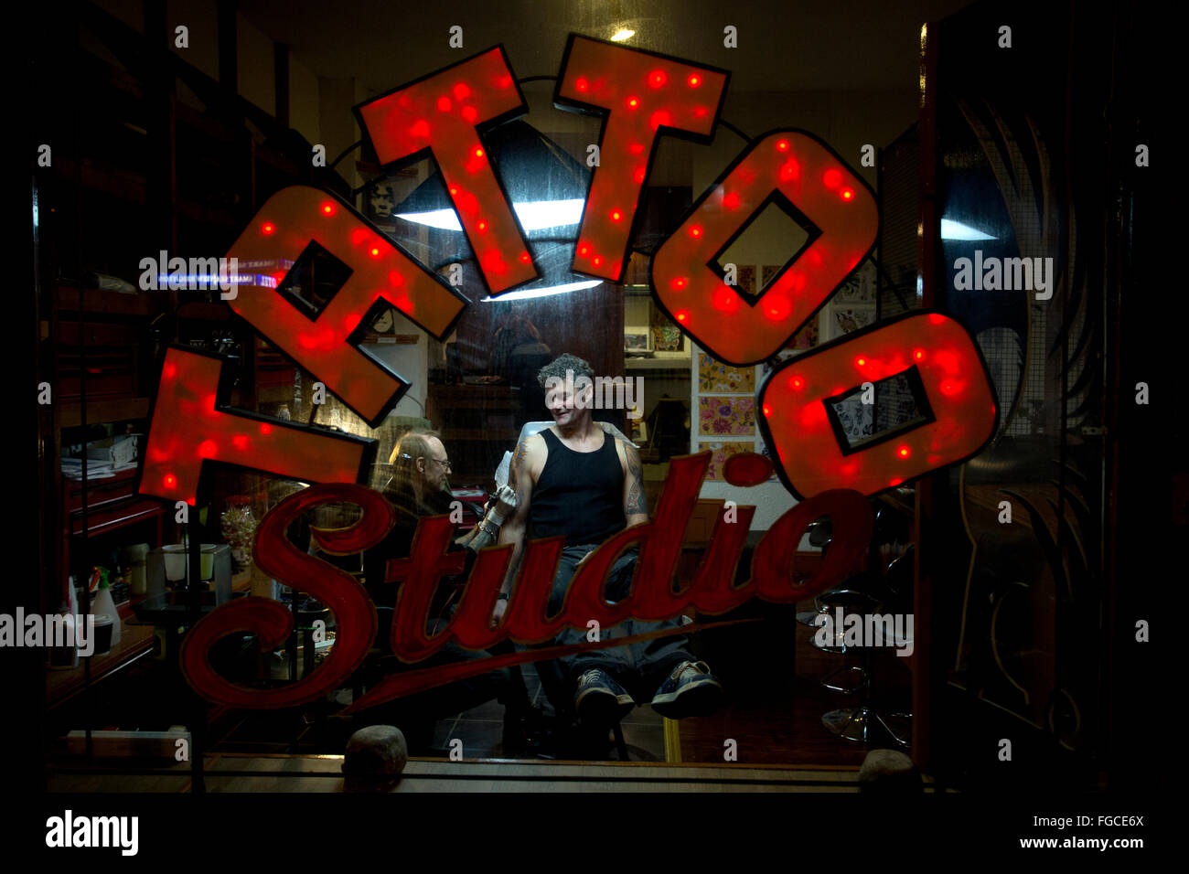 Un homme photographié dans l'obtention d'un tatouage sur son bras d'une arme à Tattoo Studio à Brighton et Hove, East Sussex, UK. Banque D'Images