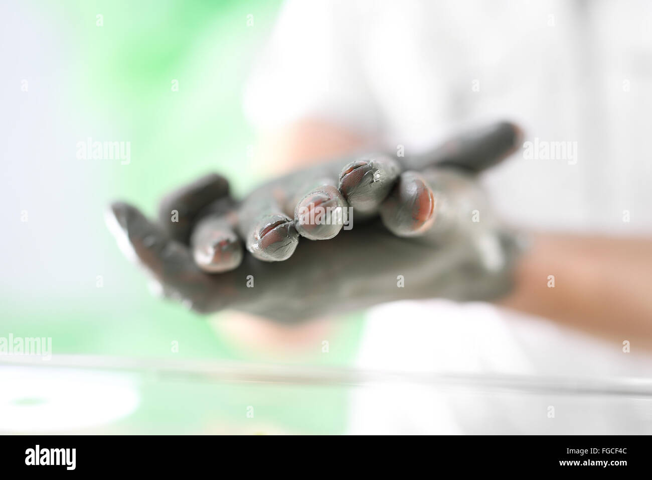 Women's Hands pendant la chirurgie cosmétique mains utilisé avec le masque à l'argile verte. Belles femmes intervention cosmétique Banque D'Images