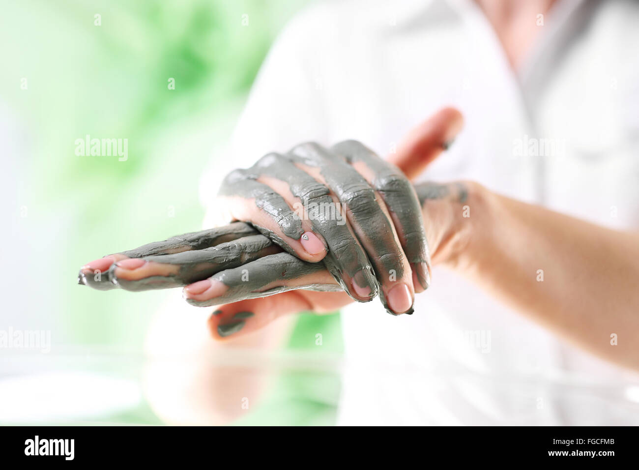 Women's Hands pendant la chirurgie cosmétique mains utilisé avec le masque à l'argile verte. Belles femmes intervention cosmétique Banque D'Images
