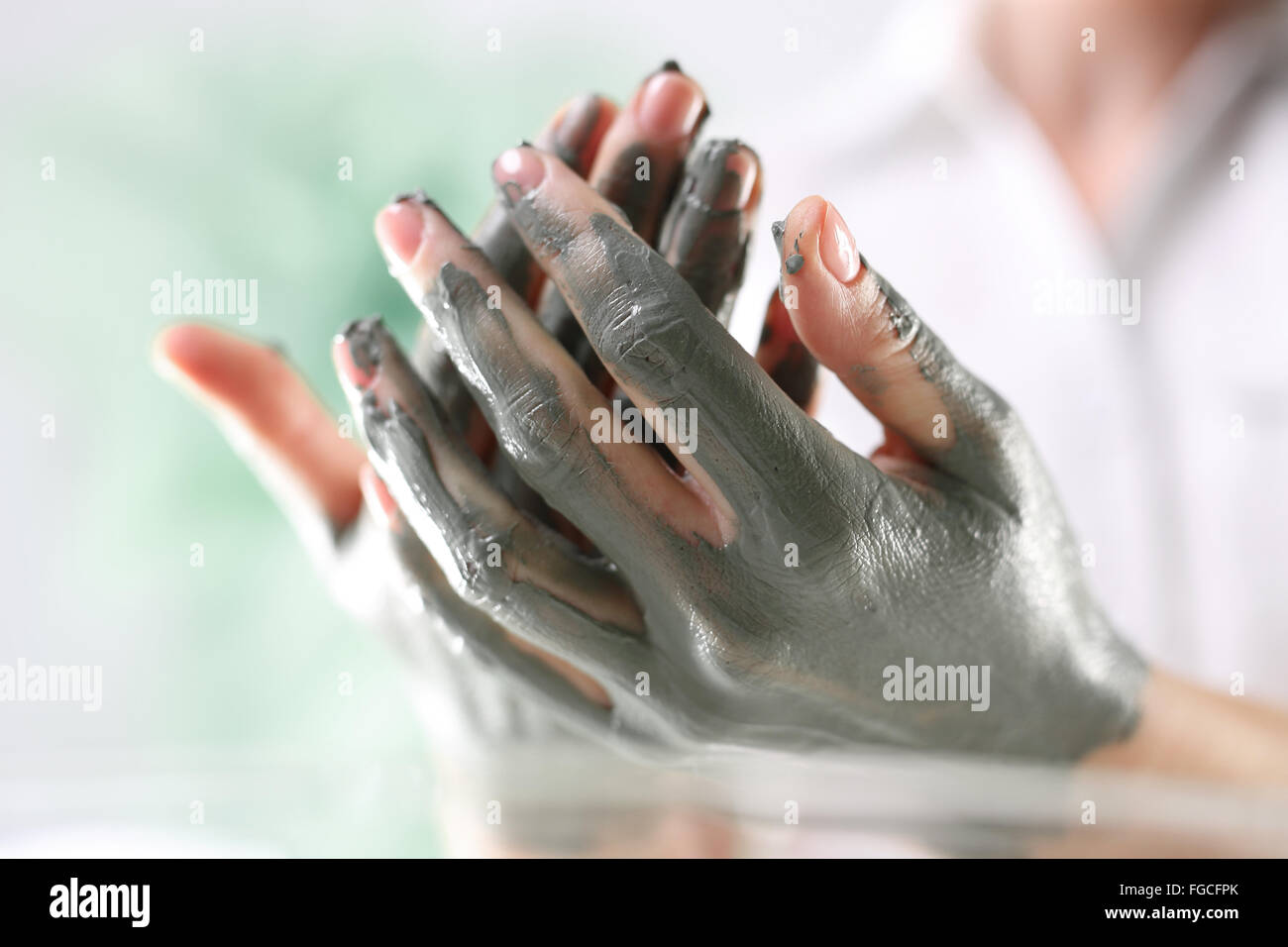 Women's Hands pendant la chirurgie cosmétique mains utilisé avec le masque à l'argile verte. Belles femmes intervention cosmétique Banque D'Images
