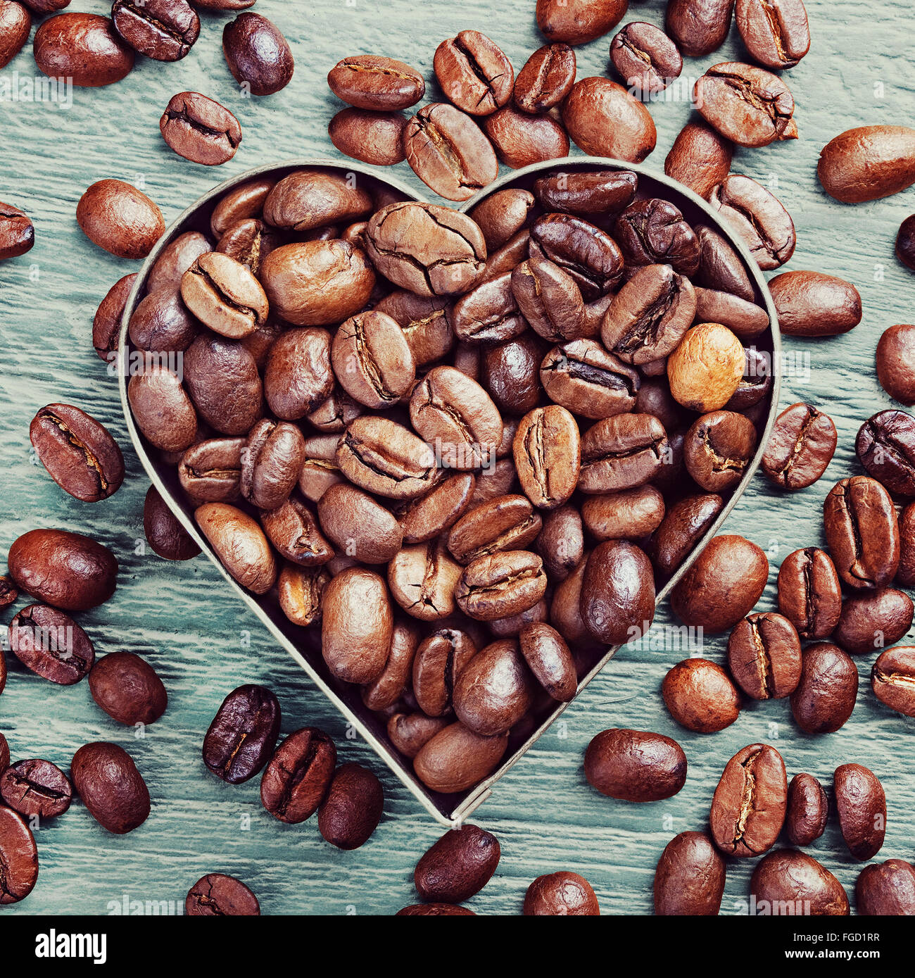 Café en grains comme arrière-plan de bon café torréfié avec cadre métallique en forme de coeur Banque D'Images