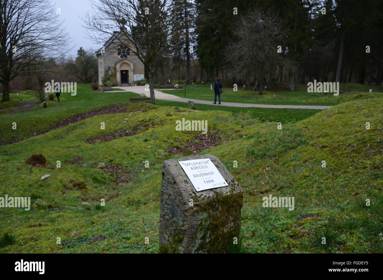 Verdun, France. 12 Février, 2016. Une pierre commémorative commémore une ferme qui a été détruit dans la WW1 batailles et jamais reconstruite, dans le village de Fleury-devant-Douaumont près de Verdun, France, 12 février 2016. Dans l'arrière-plan est la basilique Notre-Dame-de-l'Europezu Memorial Chapel. Le 100e anniversaire du début de la bataille est le 21 février 2016. PHOTO : SEBASTIAN KUNIGKEIT/DPA/Alamy Live News Banque D'Images